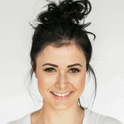 woman with long blonde hair looks at the camera with bow on her head